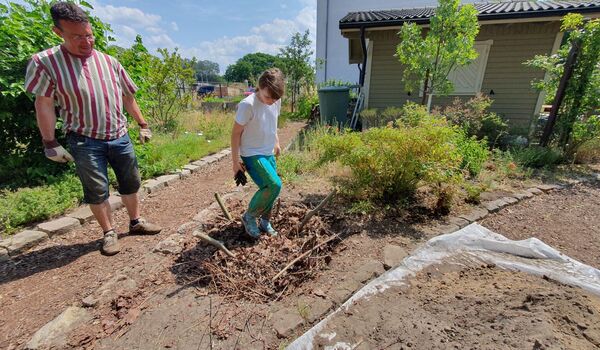 Wildbienenschaugarten Schöneweide: Ein Mädchen tritt Äste und Lauf für einen Käferkeller fest