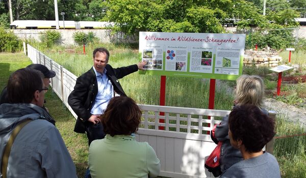 Wildbienenschaugarten Schöneweide: Cornelis Hemmer von der Stiftung für Mensch und Umwelt begrüßt Besucher*innen am Eingang des Schaugartens