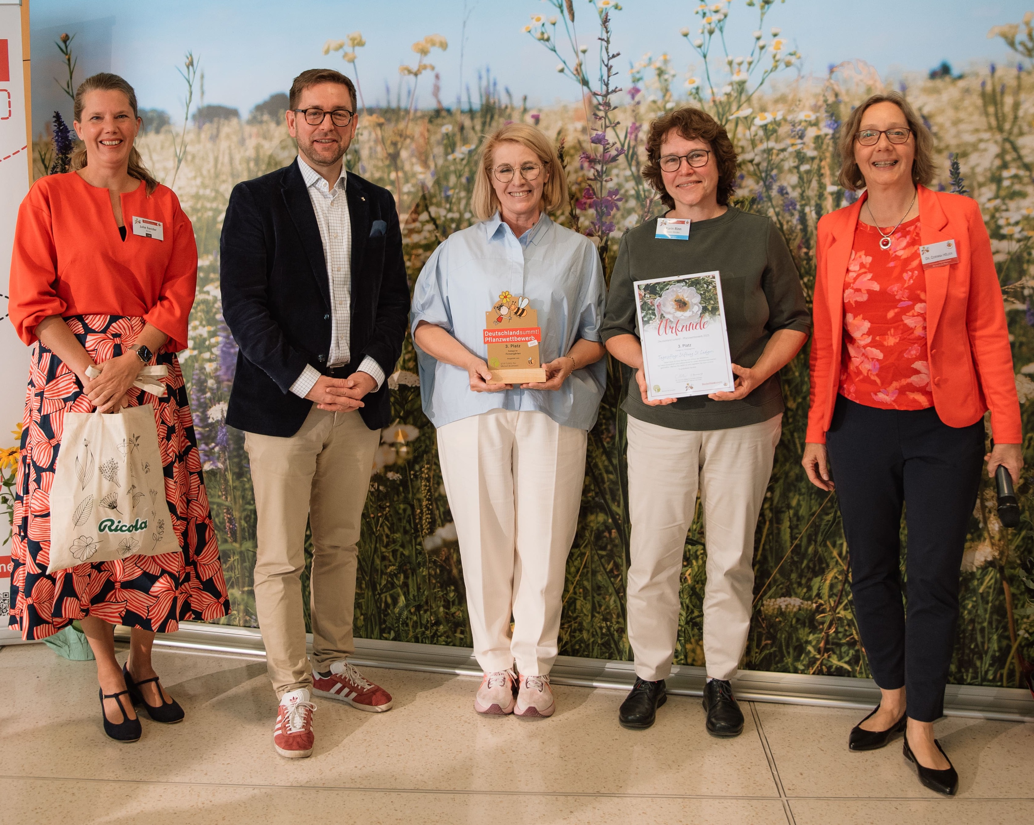 Deutschland summt!-Pflanzwettbewerb 2025: Stiftungsleiterin Dr. Corinna Hölzer (re.), Wettbewerbsleiterin Julia Sander (li.) und Staatssekretär Andreas Kraus (2. v. li.) ehren die Tagespflege der Stiftung St. Ludgeri mit einem 3. Platz.